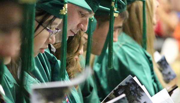 Students look at the program during the 2015 Commencement exercises at Shoreline Community College on June 7, 2015. Photo gallery  / Event video